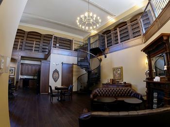 Creekside common room with a spiral staircase in the center and a leather couch in the foreground